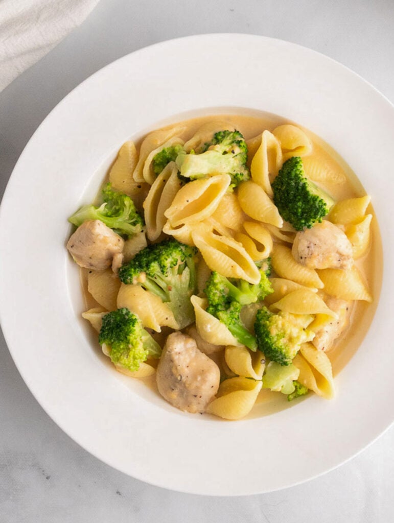 creamy broccoli chicken mac and cheese served on a white plate