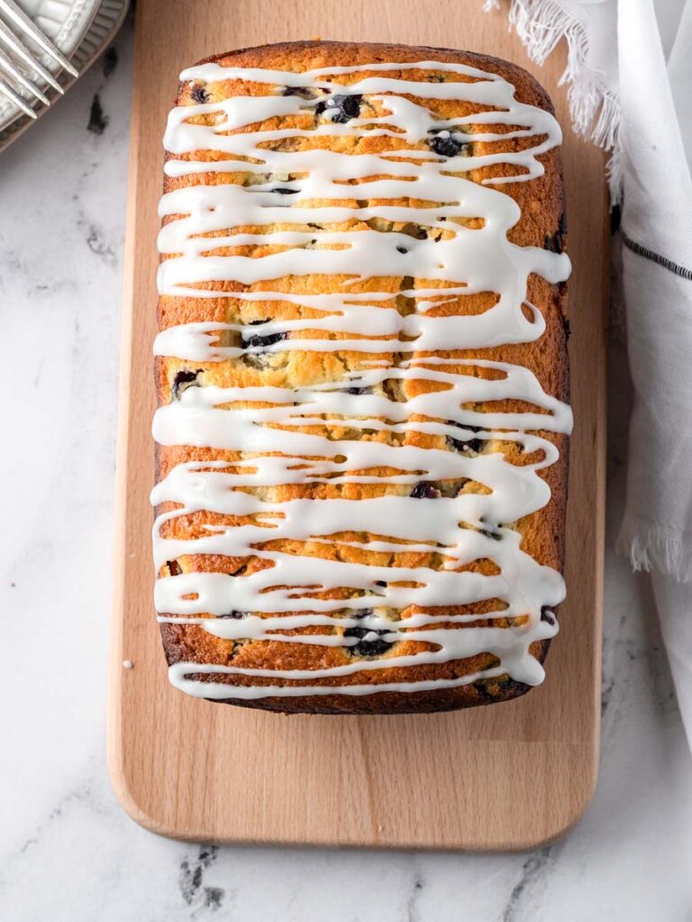 top down shot of blueberry lemon bread, with drizzles of glaze on top