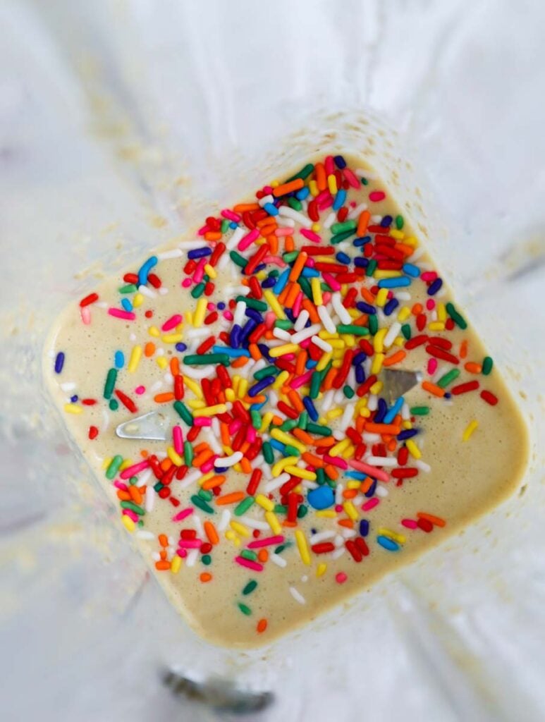 Batter being mixed with sprinkles in a blender.