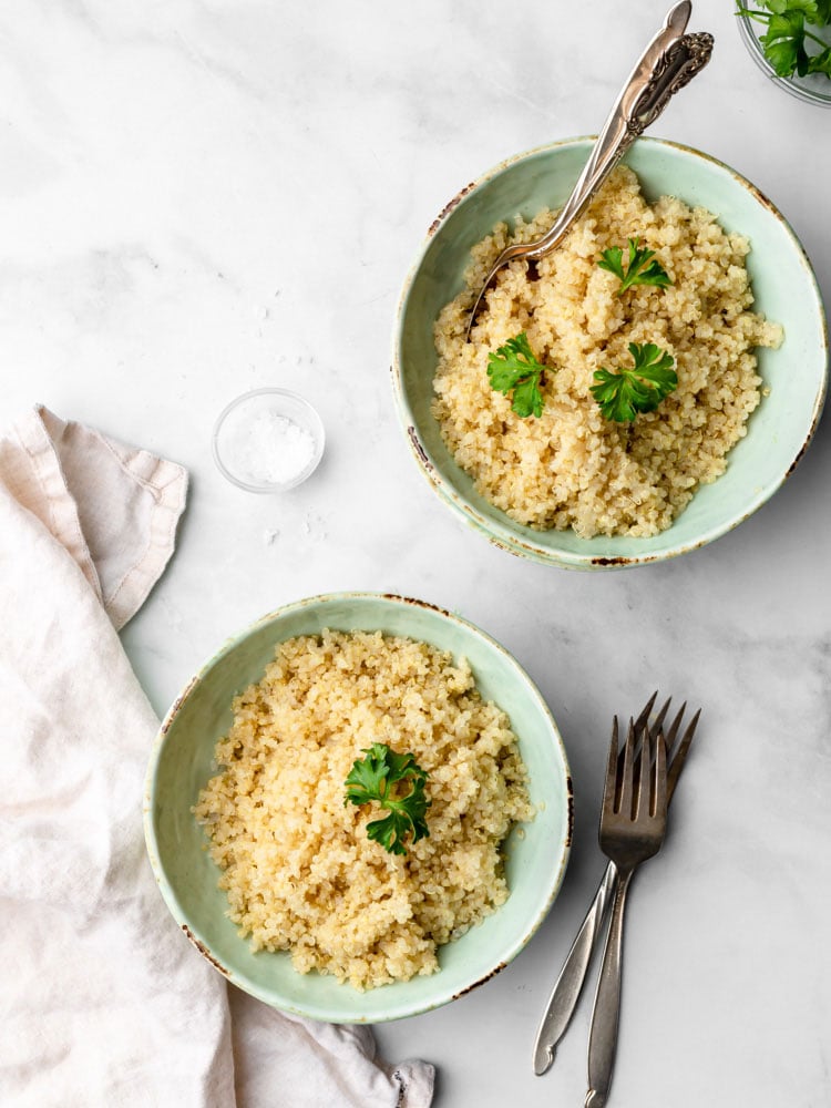 two bowls of cooked quinoa garnished with parsley