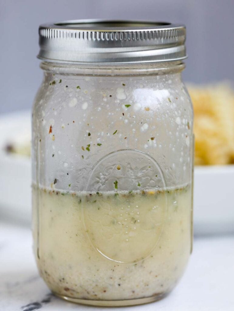 Mason jar with Greek dressing.