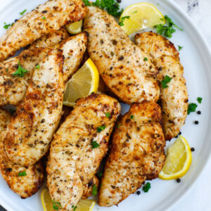 Top down view of lemon pepper chicken on a plate.