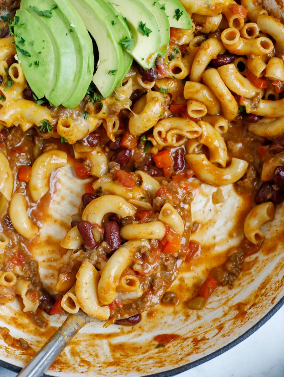 Close upo f a pot of chili mac being scooped with a spoon.