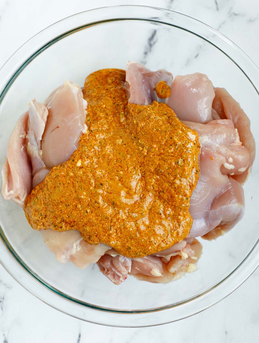Marinade poured over top of chicken thighs before and after mixing together