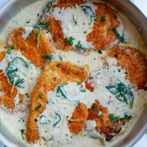 Overhead view of creamy parmesan chicken breasts inside of a pan.