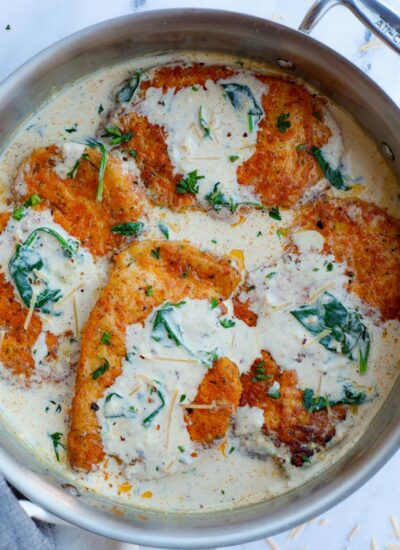 Overhead view of creamy parmesan chicken breasts inside of a pan.