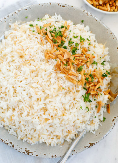 Top down view of of cooked vermicelli rice on a plate, garnished with toasted almonds and parsly