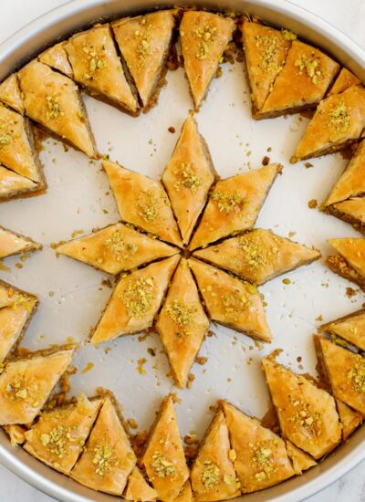 Walnut baklava in a pan with pieces removed.