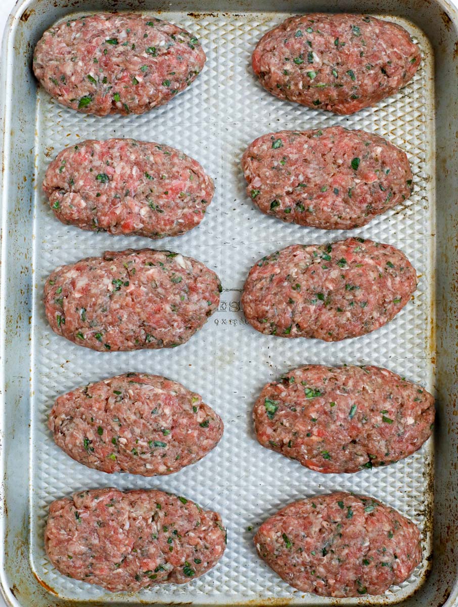 Kafta patties on a sheet pan.