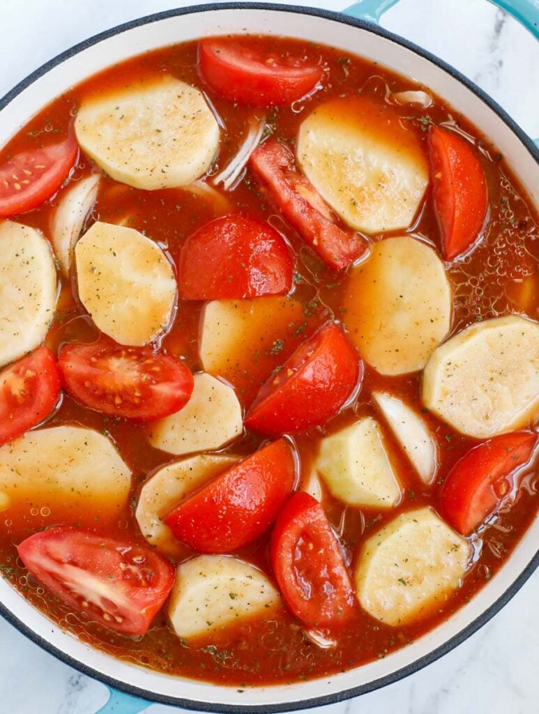 Potatoes and tomatoes in a pot, simmering.