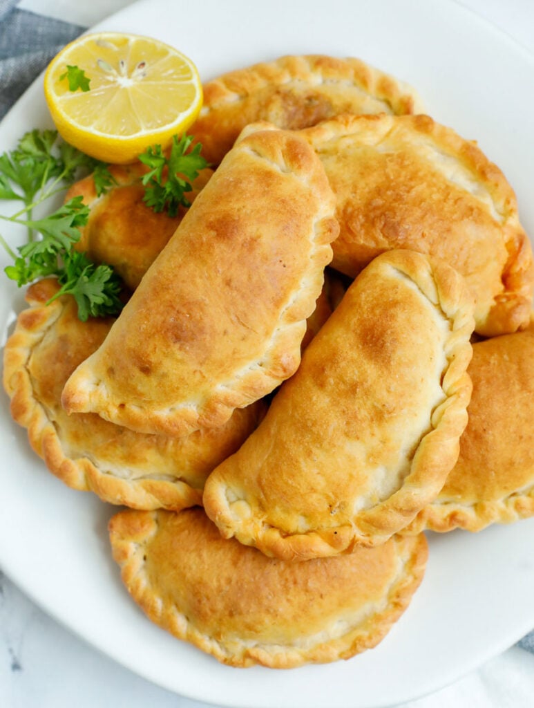 A platter of freshly baked individual meat pies.