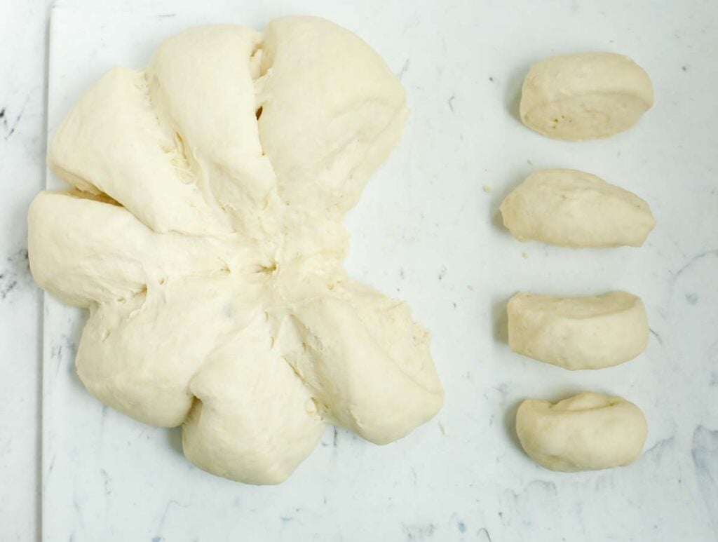 Cutting dough to shape into small dough balls.