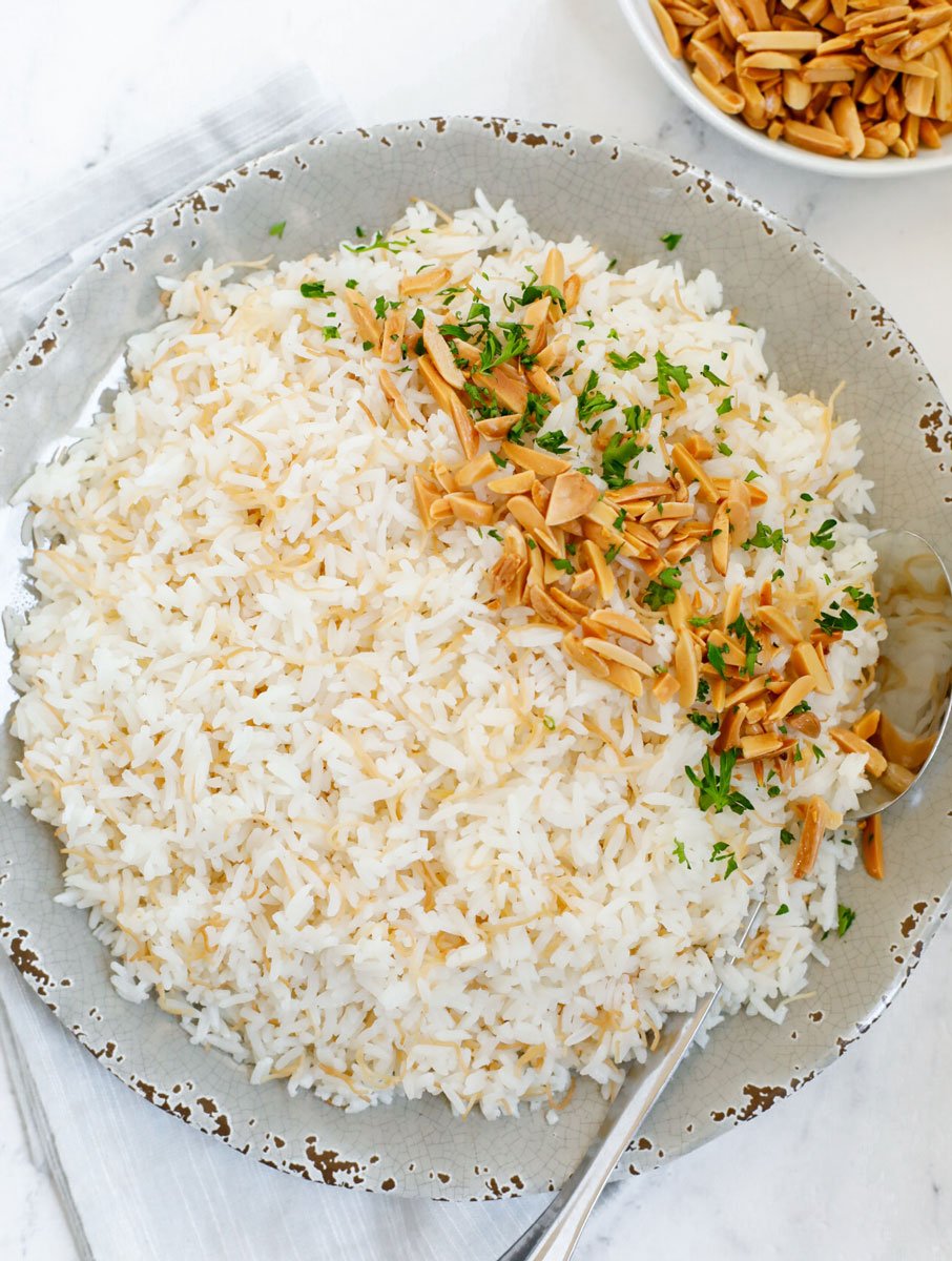 vermicelli rice served on a plate with toasted almonds and garnished with parsley