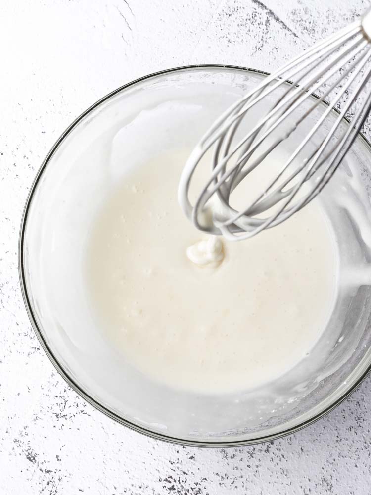 lemon sugar icing in a bowl with whisk