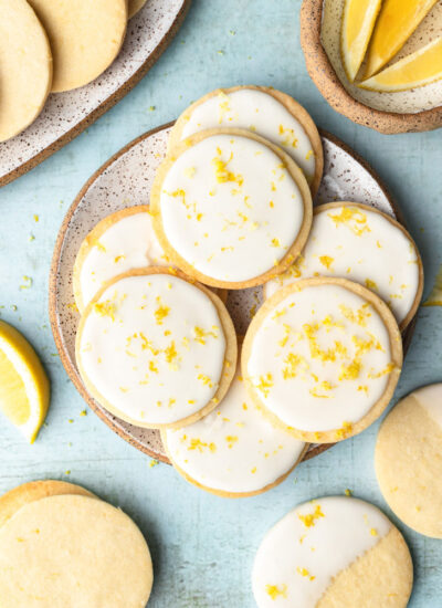 top down shot showing the lemon cookies with icing on a plate with blue background