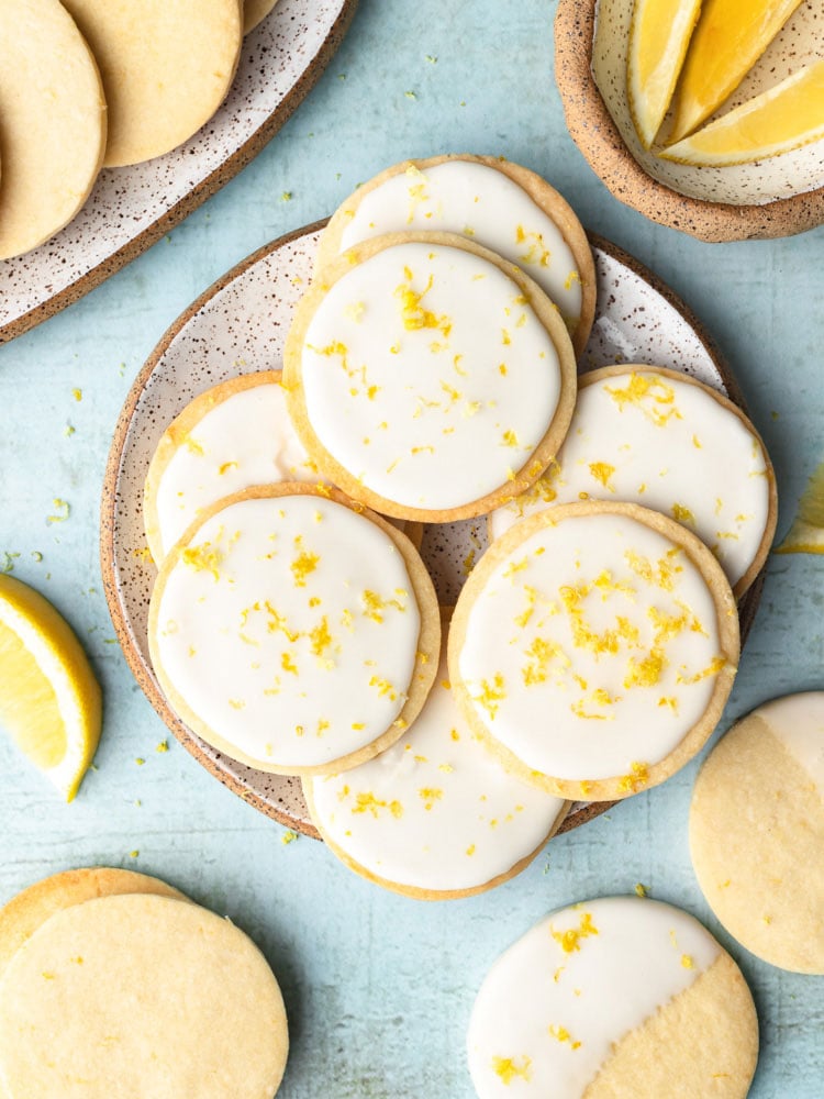 top down shot showing the lemon cookies with icing on a plate with blue background