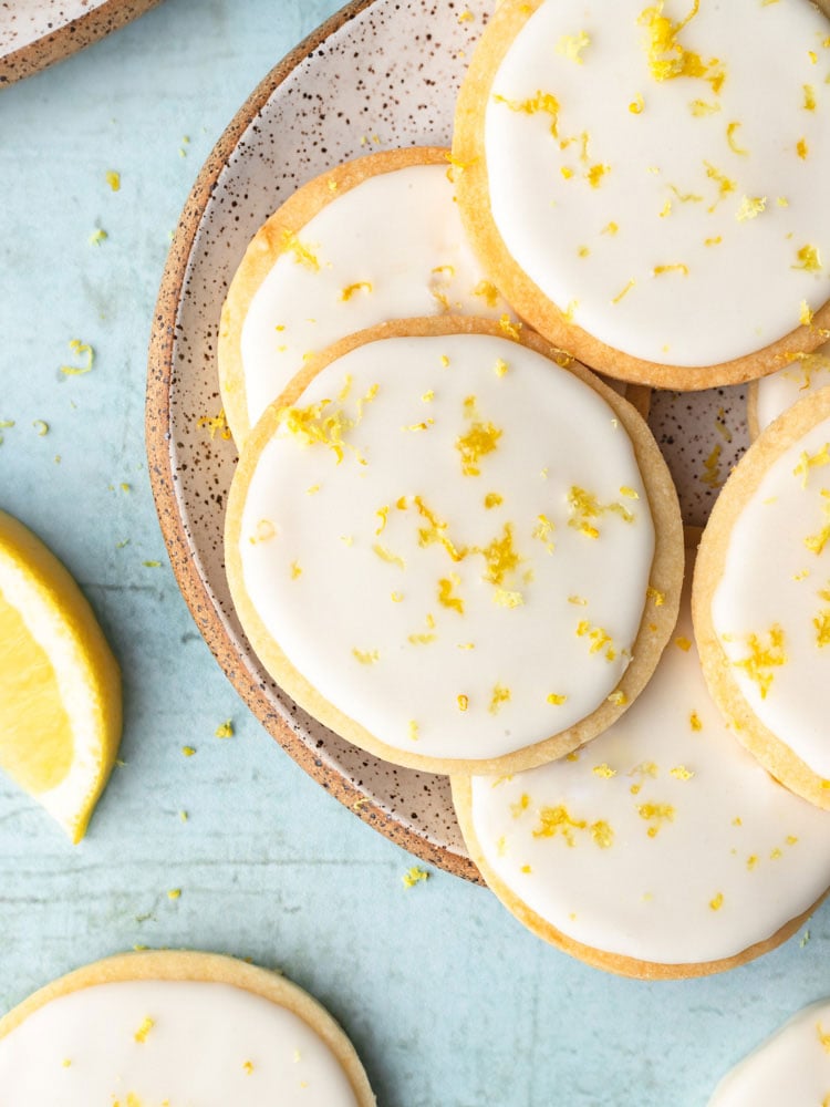 top down shot showing the lemon cookies with icing on a plate with blue background