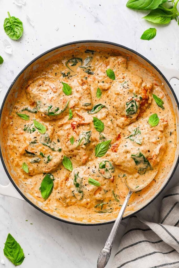 top down view of the creamy chicken thighs dish, garnished with basil leaves