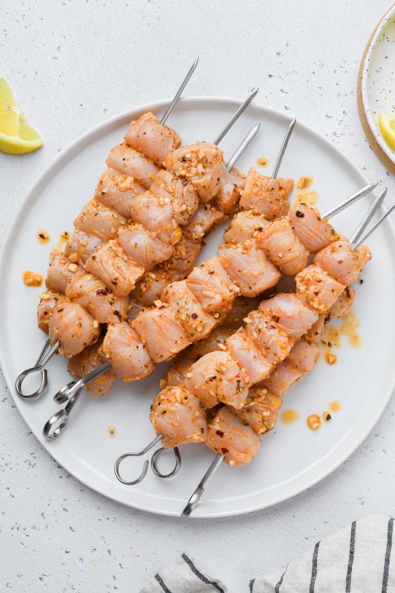 marinated greek chicken skewers before grilling