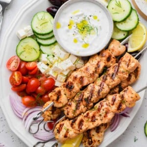 top down shot of the greek chicken skewer dish served with sides