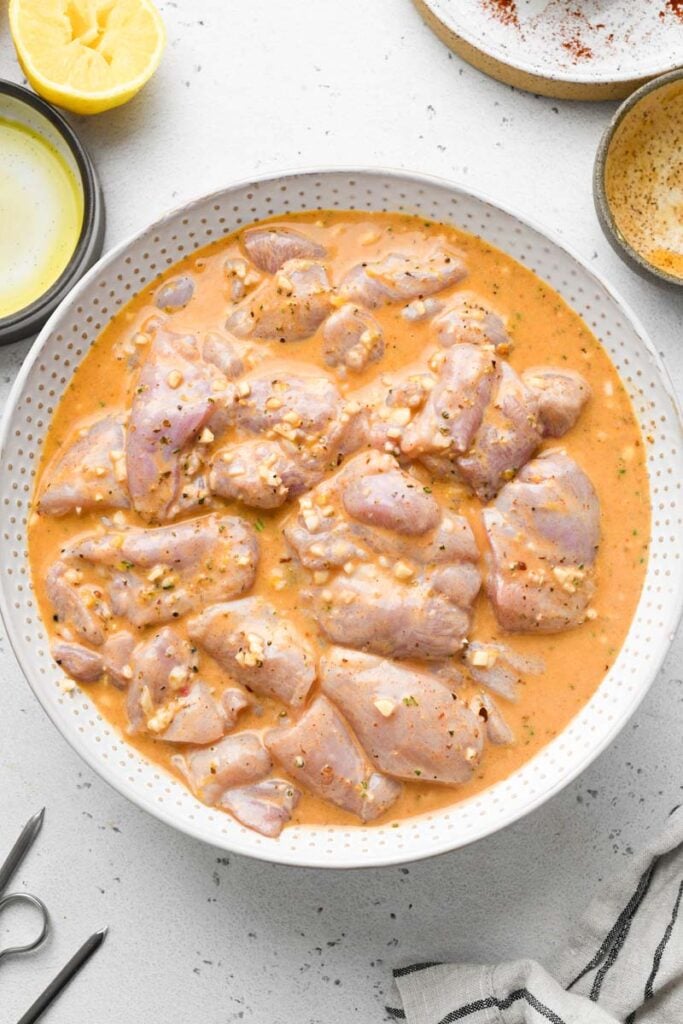 chicken marinated in the lemon garlic sauce in a bowl