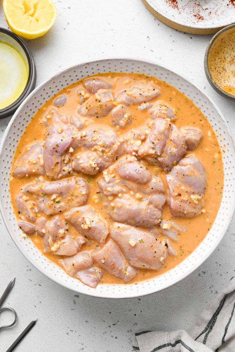 chicken marinated in the lemon garlic sauce in a bowl