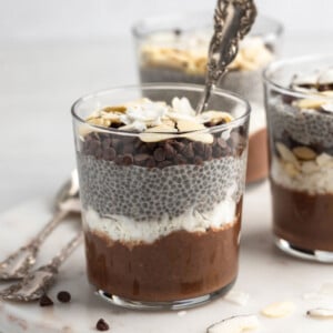 front view shot of almond joy chia pudding with a spoon in the cup