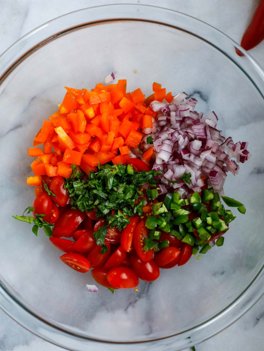 Bowl of the vegetables (tomatoes, bell pepper, pepper, onions, and parsley).