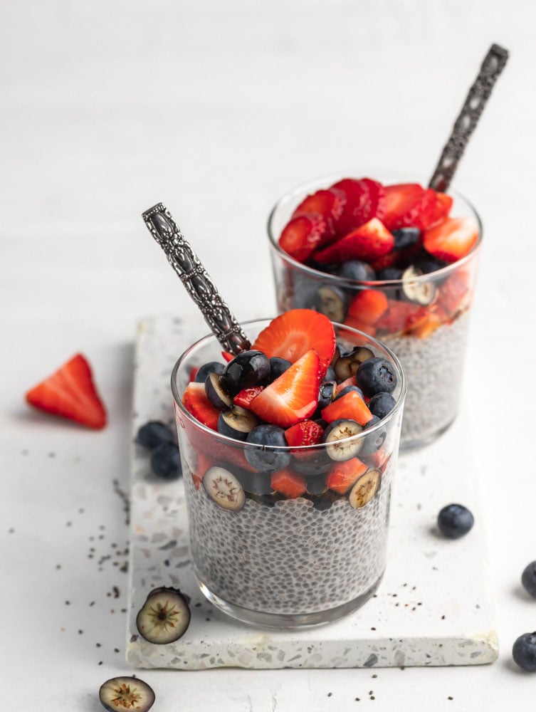 two chia seed puddings in a cup topped with fruits