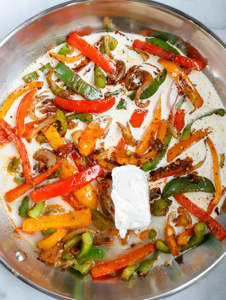 Heavy cream and cream cheese added to a skillet.