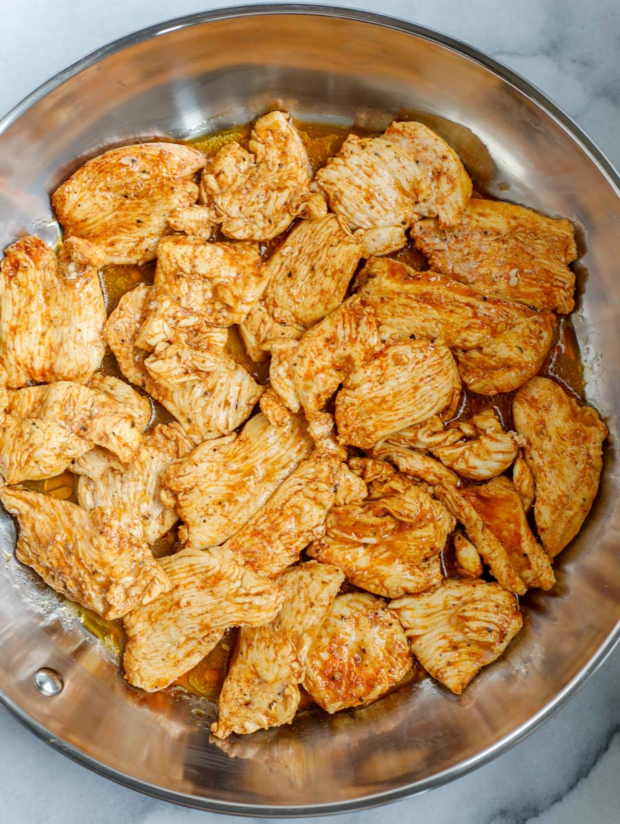 Chicken being seared in a pan.