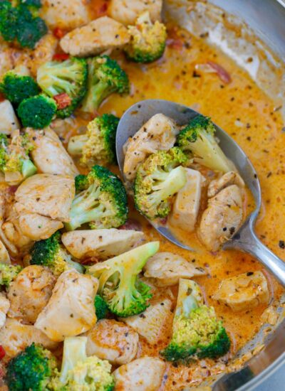 Close up of a spoonful of sun-dried tomato chicken and broccoli.