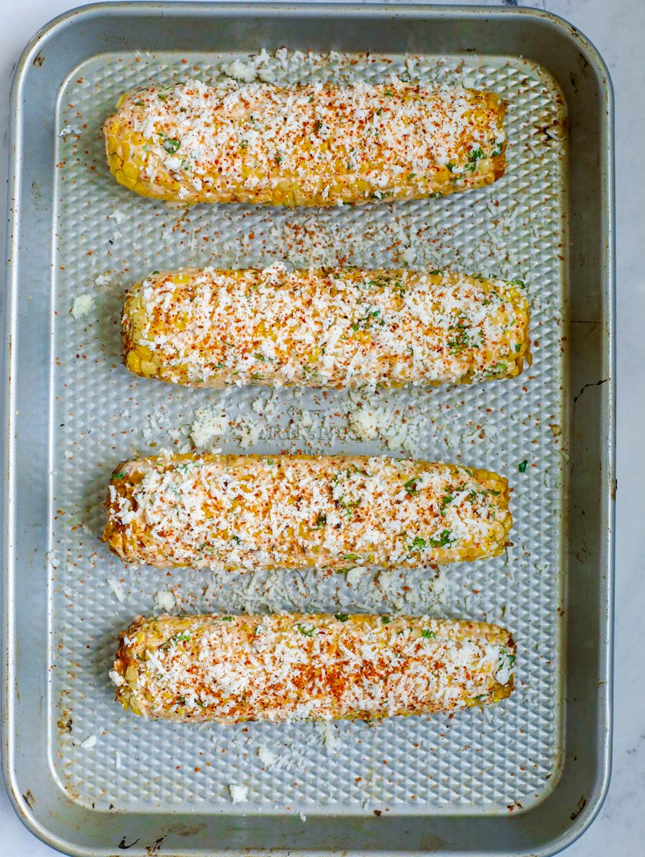 Mexican corn on a sheet pan with tajin seasonig added.