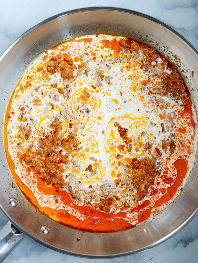 Stirring together sun-dried tomato sauce in a pan.