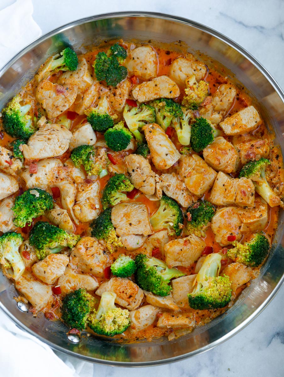 A pan of creamy sun-dried tomato chicken and broccoli.