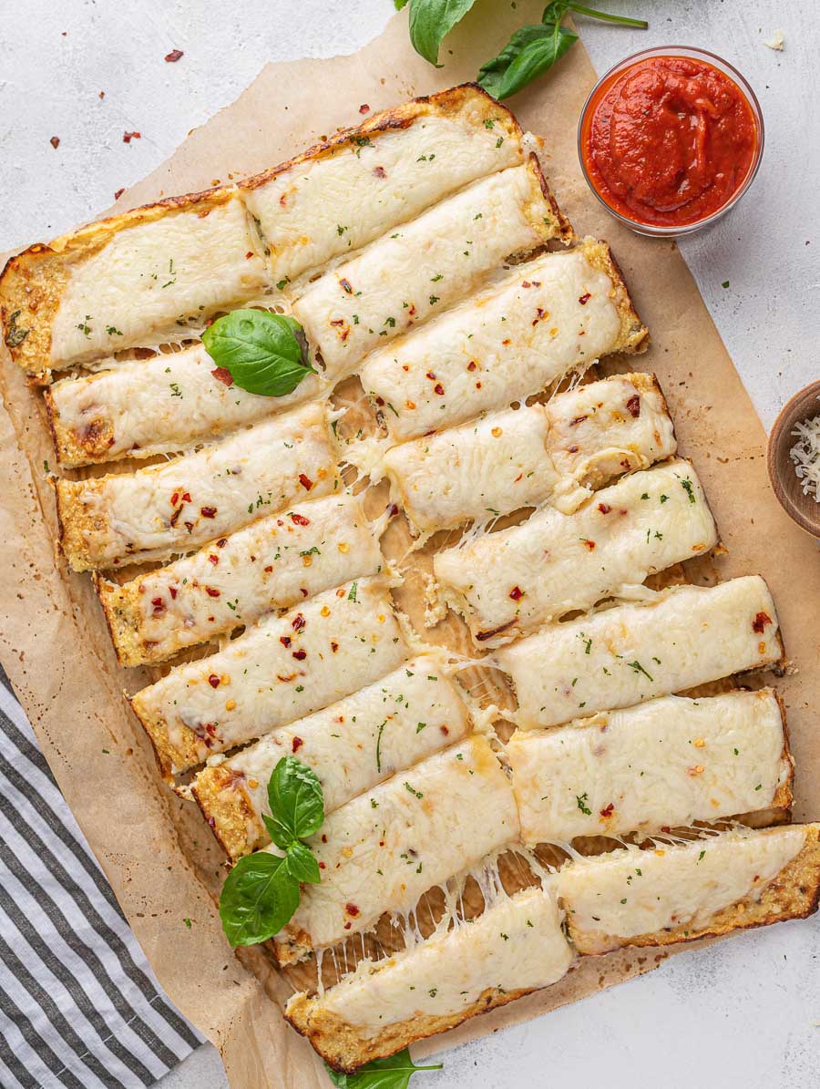 top down shot of cauliflower sticks with basil leaves on top