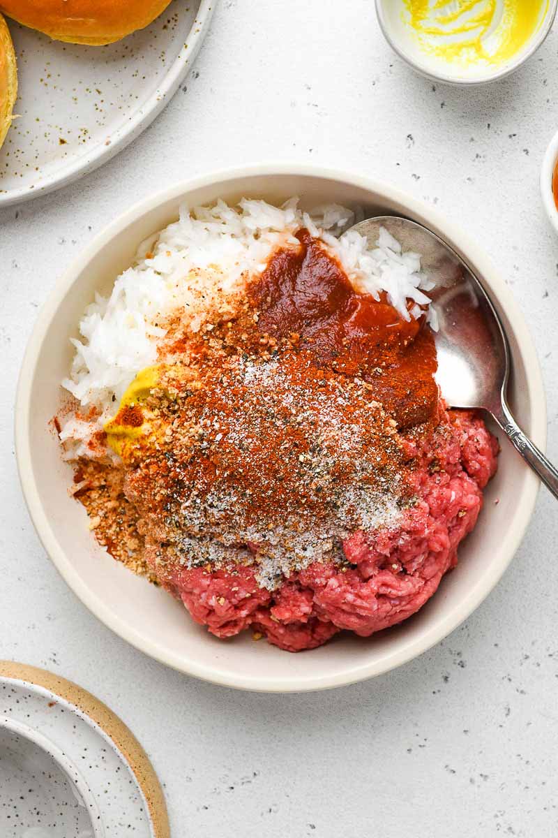 Ingredients for beef patties in a bowl.