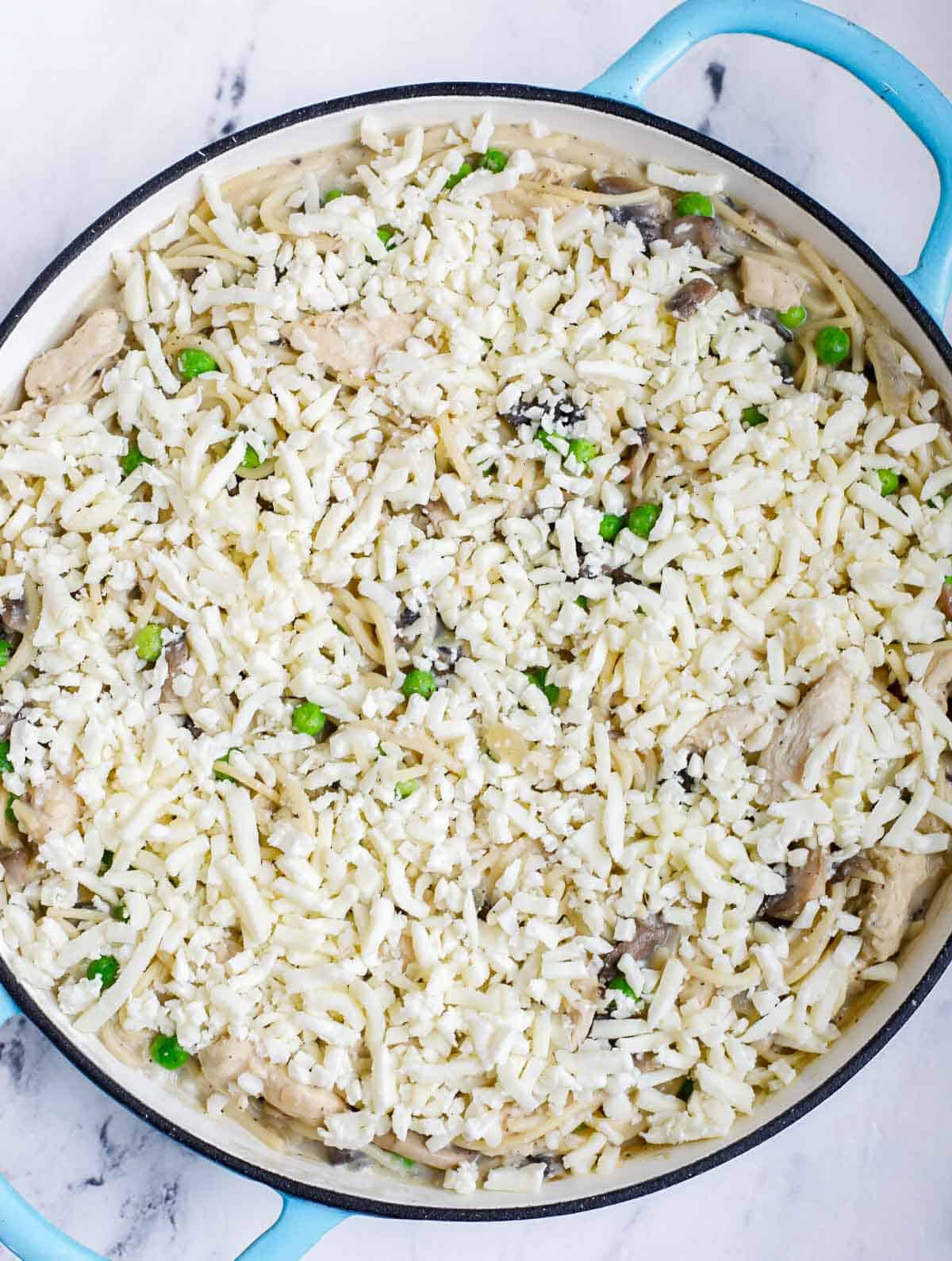 Cheese added to chicken tetrazzini before baking.