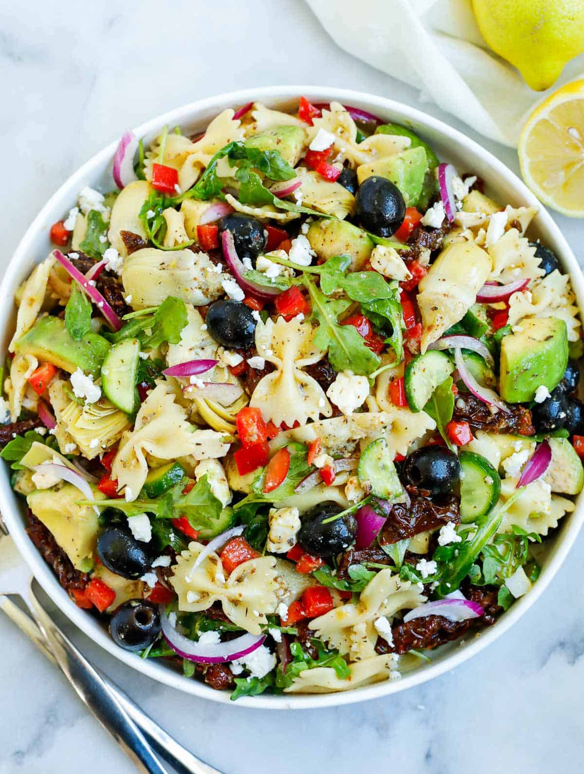 lemon herb Mediterranean salad served in a white bowl, with a side of lemon