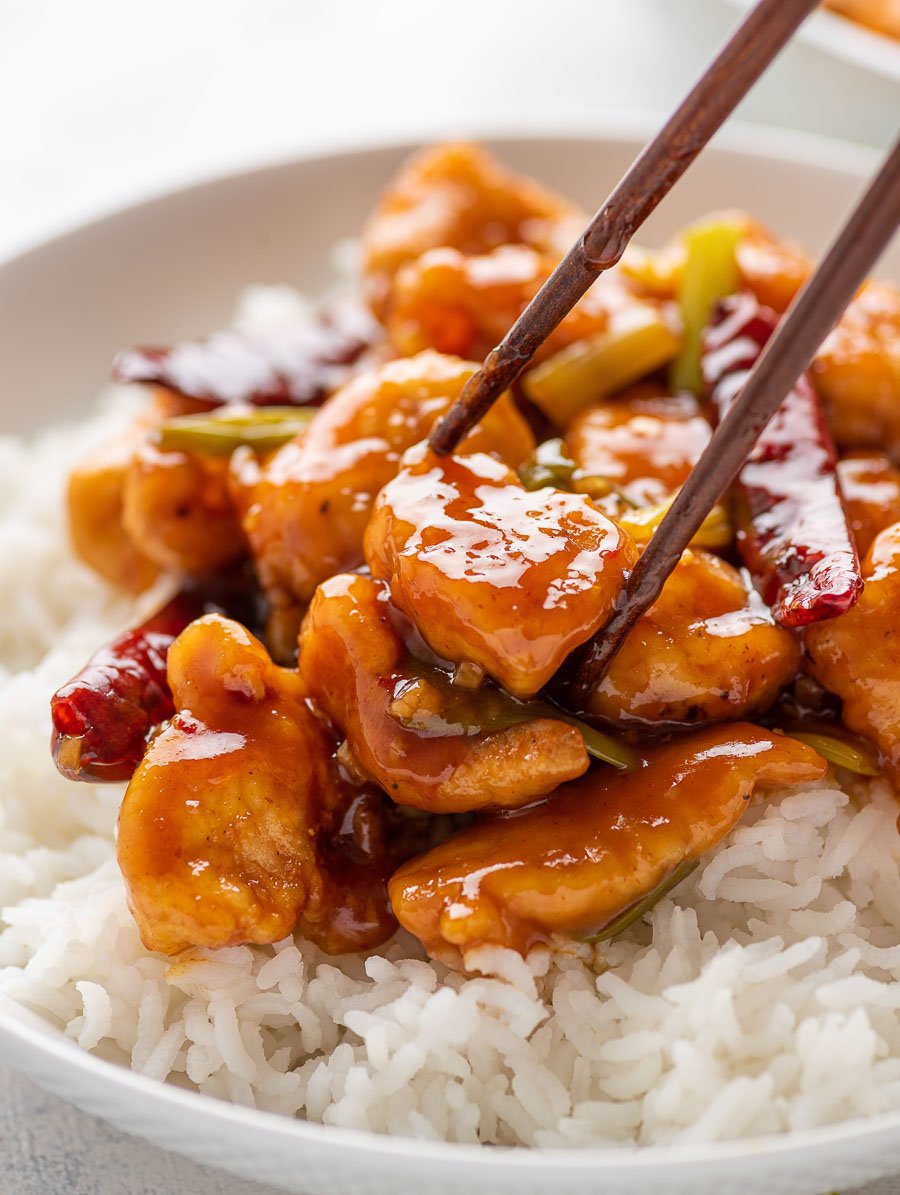 chop stick holding onto a piece of mongolian chicken