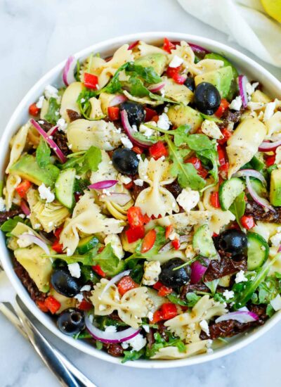 lemon herb Mediterranean salad served in a white bowl, with a side of lemon