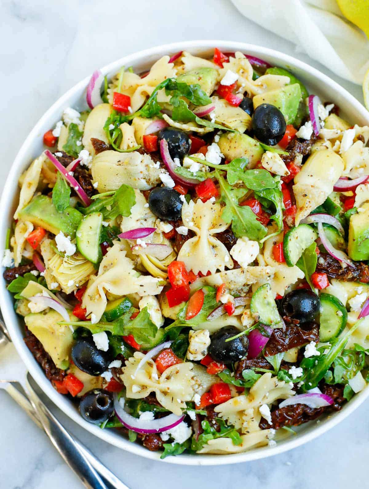 lemon herb Mediterranean salad served in a white bowl, with a side of lemon