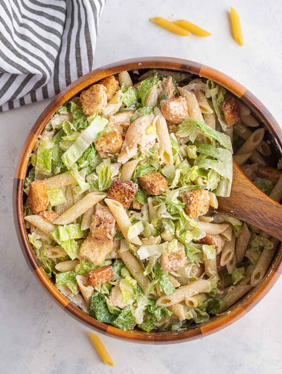 chicken ceasar pasta salad in a wooden bowl