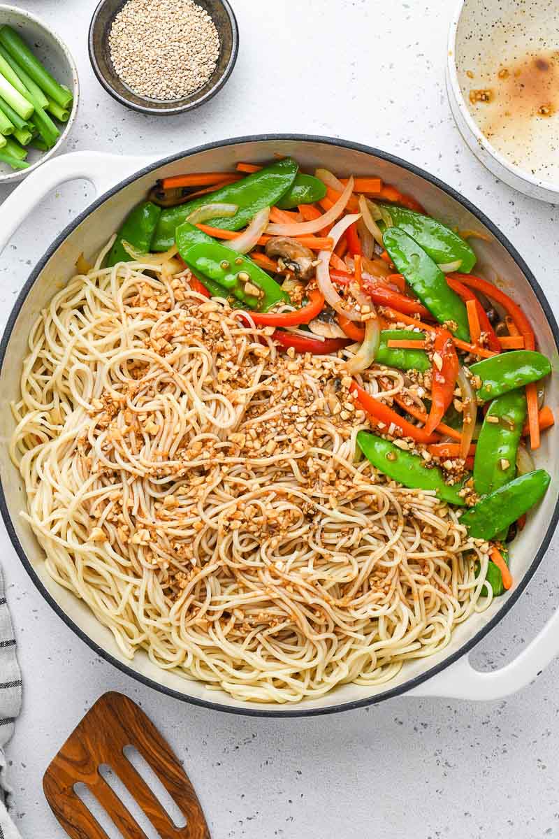 sauce poured over the lo mein noodles in a skillet