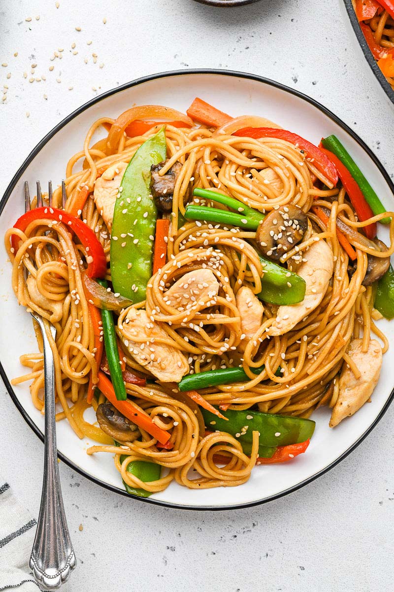 chicken lo mein on a plate i with a fork