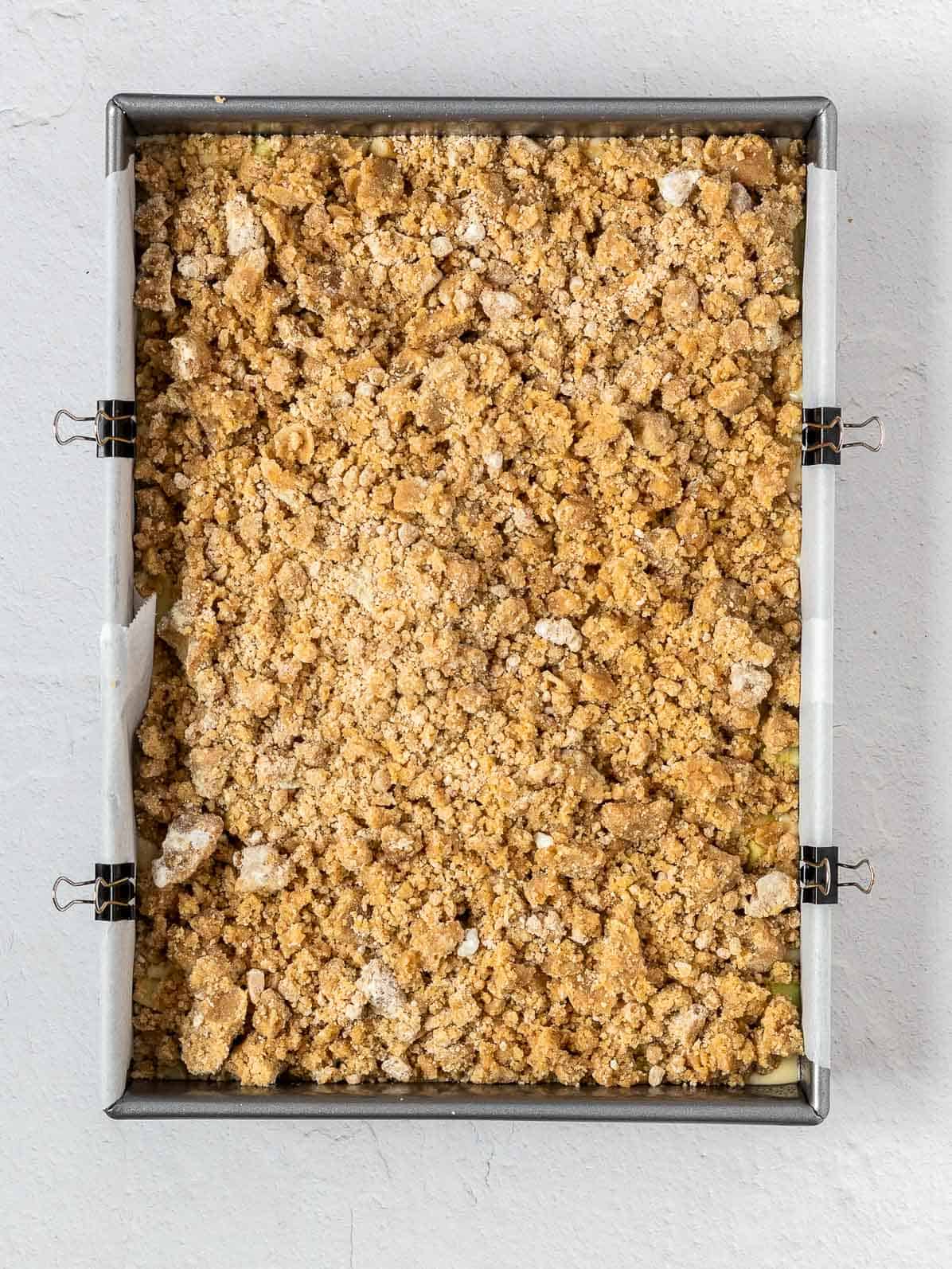 apple crumb cake before baking in a rectangular pan