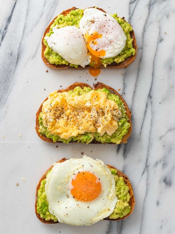 3 avocado toasts topped with fried, scrambled and pouched egg.