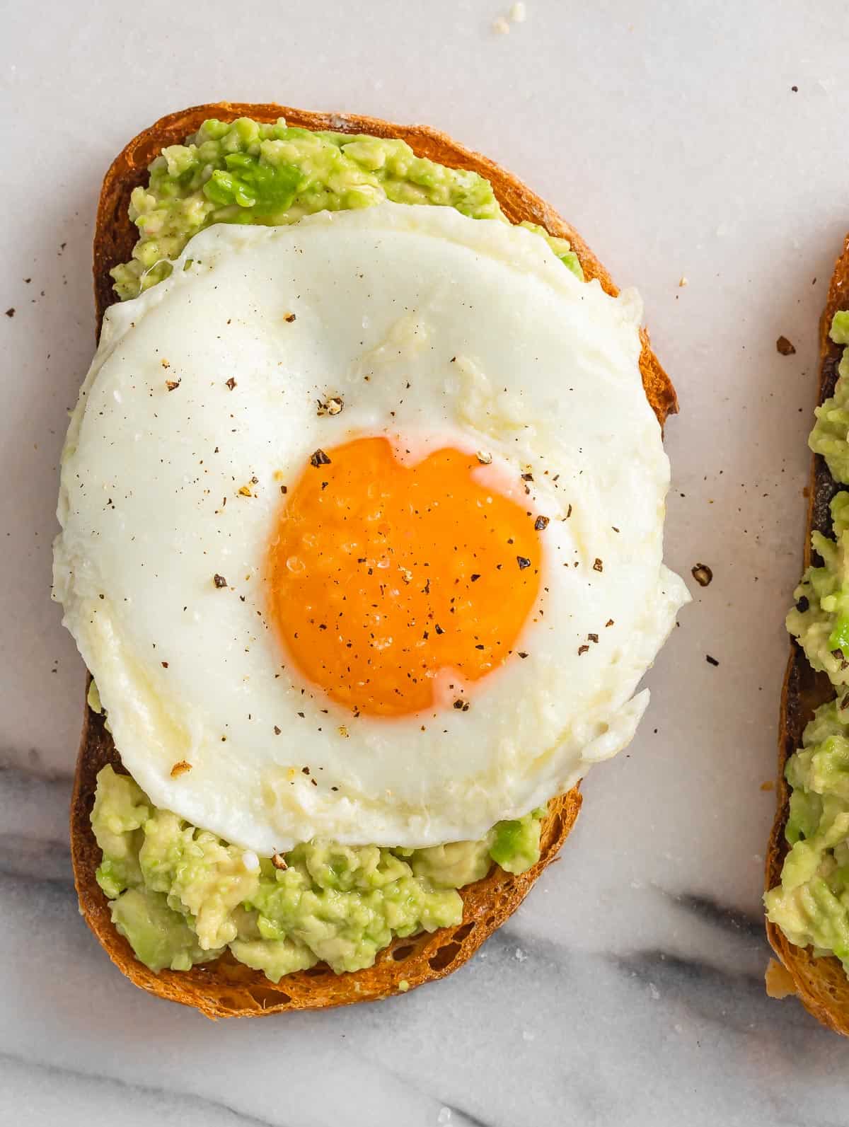 Avocado on toast bread topped with a fried egg