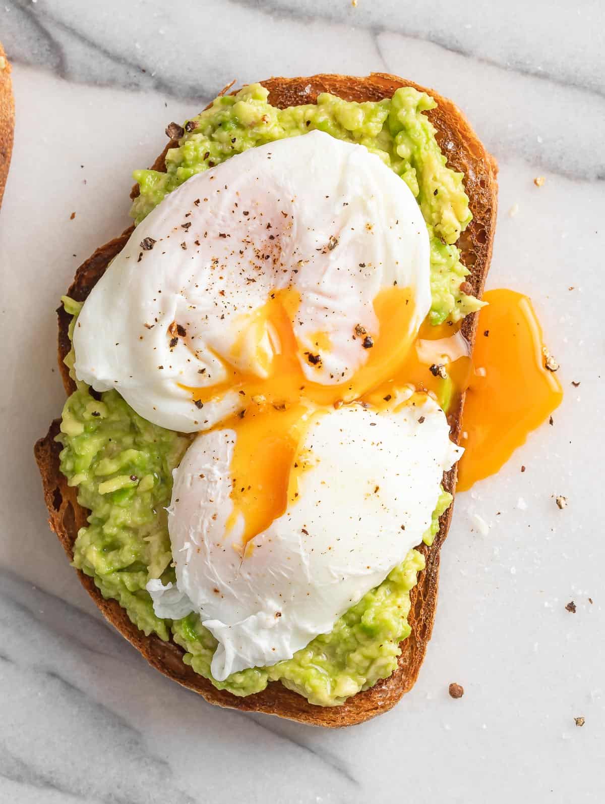 Avocado on toast bread topped with pouched egg