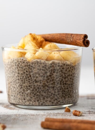 Overnight Chia Pudding topped with apples and a cinnamon stick.